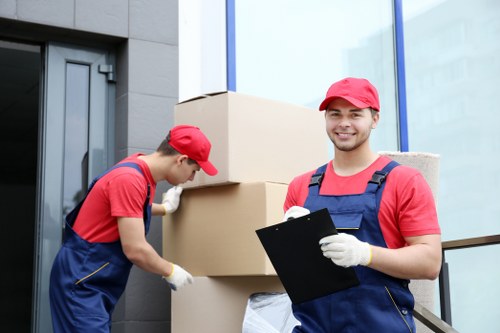 Trained removals staff using safe lifting techniques during a relocation