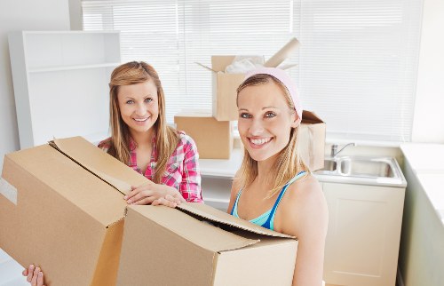 Furniture being carefully carried through a North London apartment building